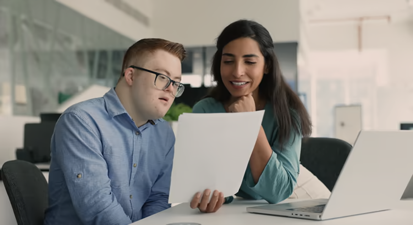 Two employees reviewing a document at a desk