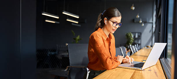 Woman working on a laptop analyzing business intelligence dashboards