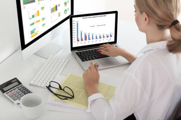 People analyzing attendance and revenue data on monitors