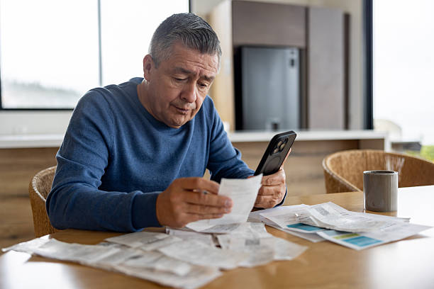 Man looking at his phone and papers