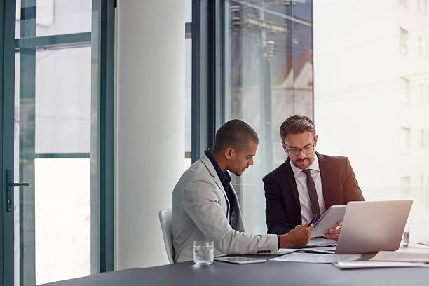 Two managers discussing attendance structure at a desk