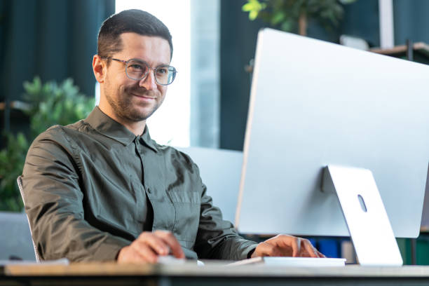Manager smiling while looking at actionable insights on computer
