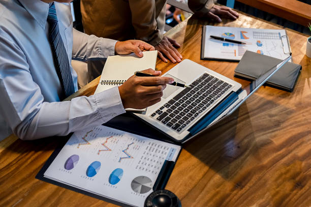 People reviewing charts and laptop