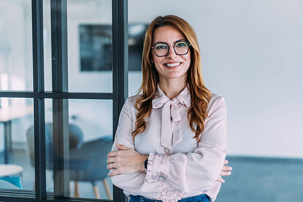 Woman smiling with arms crossed in an office
