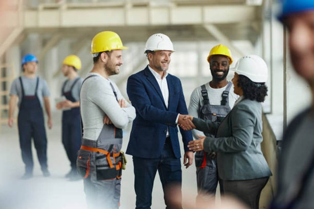 Construction workers and managers discussing job site attendance