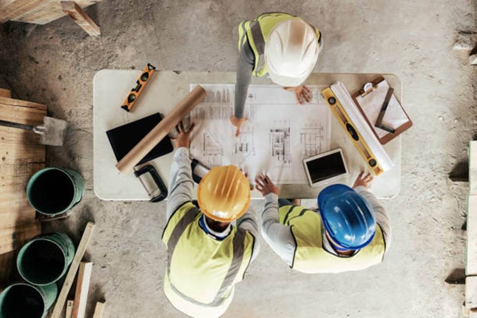 Construction workers reviewing plans from above