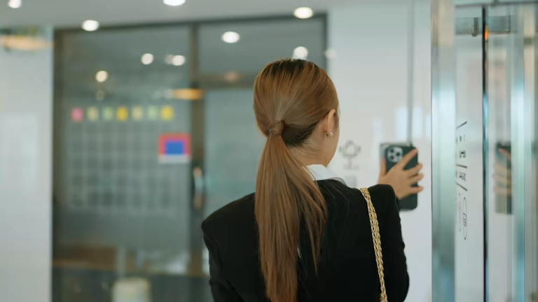 Woman using smartphone near elevator for attendance