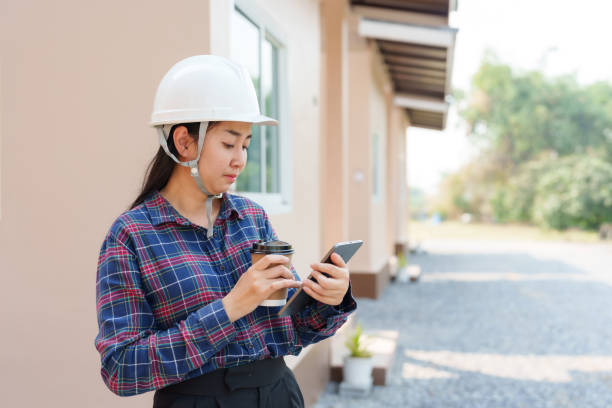 Woman in hardhat looking at smartphone