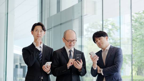 Three businessmen looking at their phones