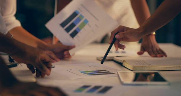 People looking at charts and graphs on paper