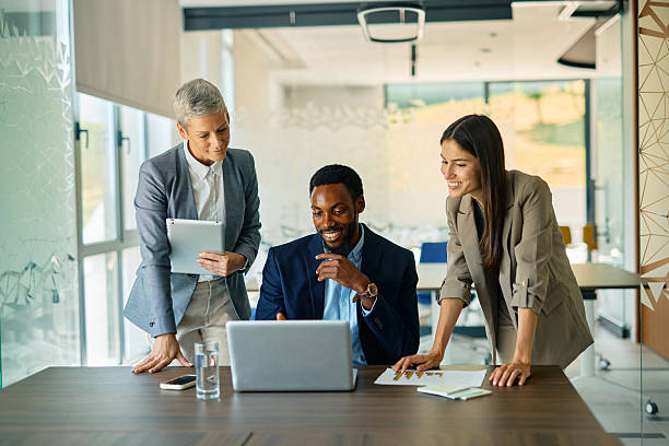 Three colleagues looking at a laptop