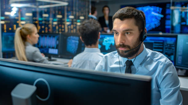 Call center workers with headsets looking at computer monitors