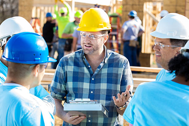 Construction workers with safety gear discussing plans