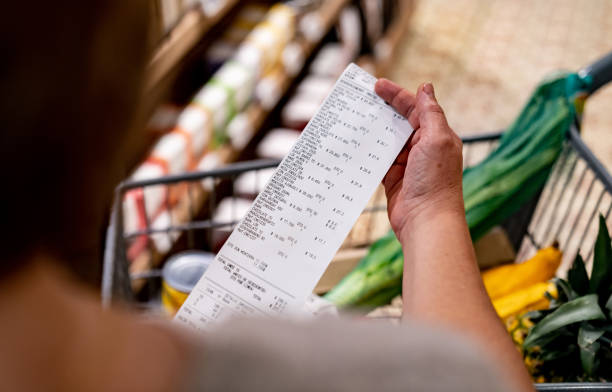 Person holding a long receipt or invoice
