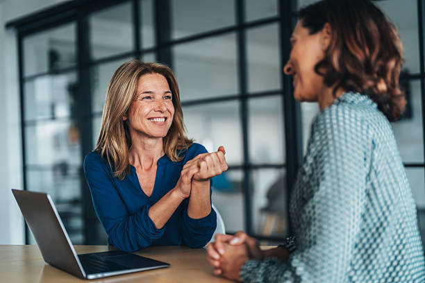 Two women talking with a laptop on the desk