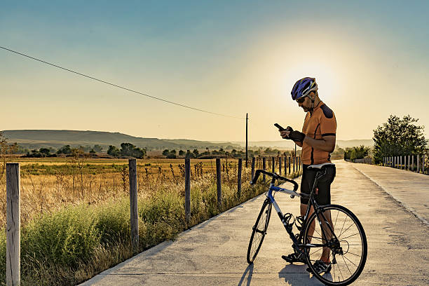 Cyclist looking at their smartphone on a path