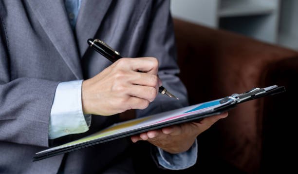 Person holding a clipboard and pen
