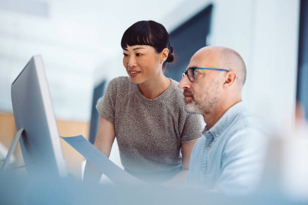 Two employees looking at a computer monitor