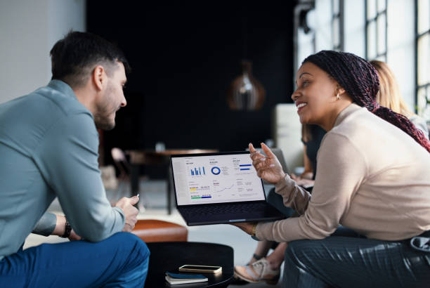 Two employees looking at a laptop