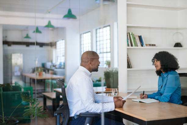 Two people at a desk discussing a step-by-step guide