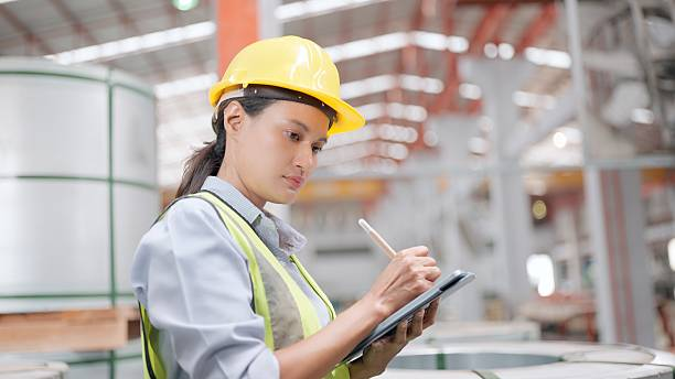 Female worker in a warehouse writing on a clipboard