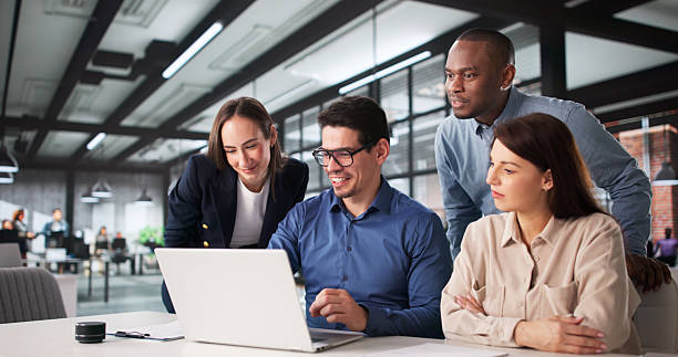 Team collaborating around a laptop