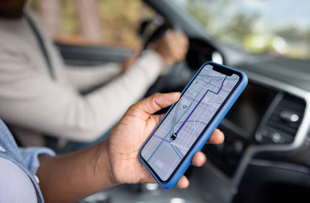 Person holding a smartphone with GPS map in a car