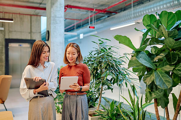 Two women looking at tablets in an office setting