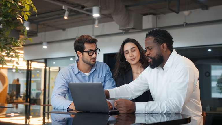Three people looking at a laptop