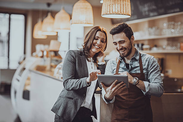 Man and woman looking at a tablet in a cafe