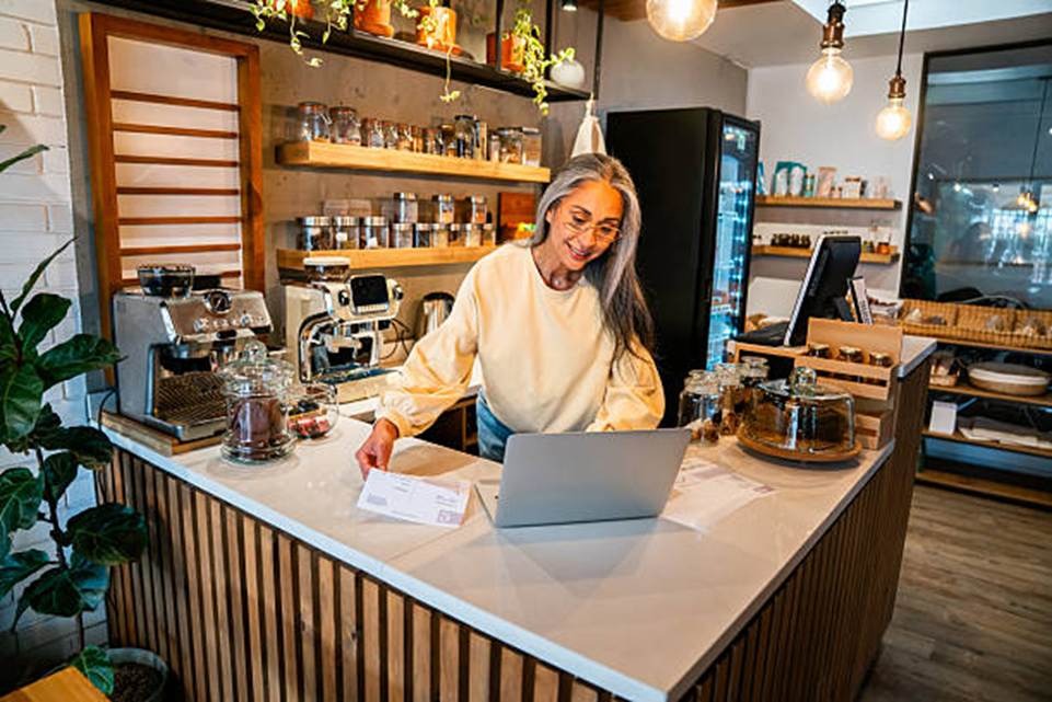 Small business owner using secure payroll software in a cafe