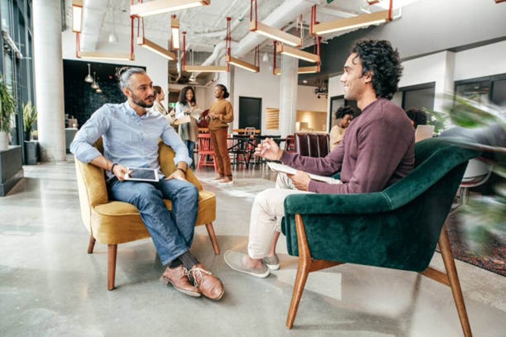 Two employees discussing engagement and workplace goals in an office