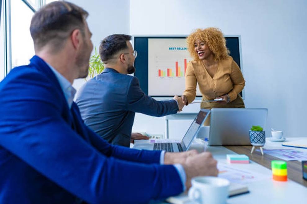 Employee recognition meeting with handshake and business performance chart