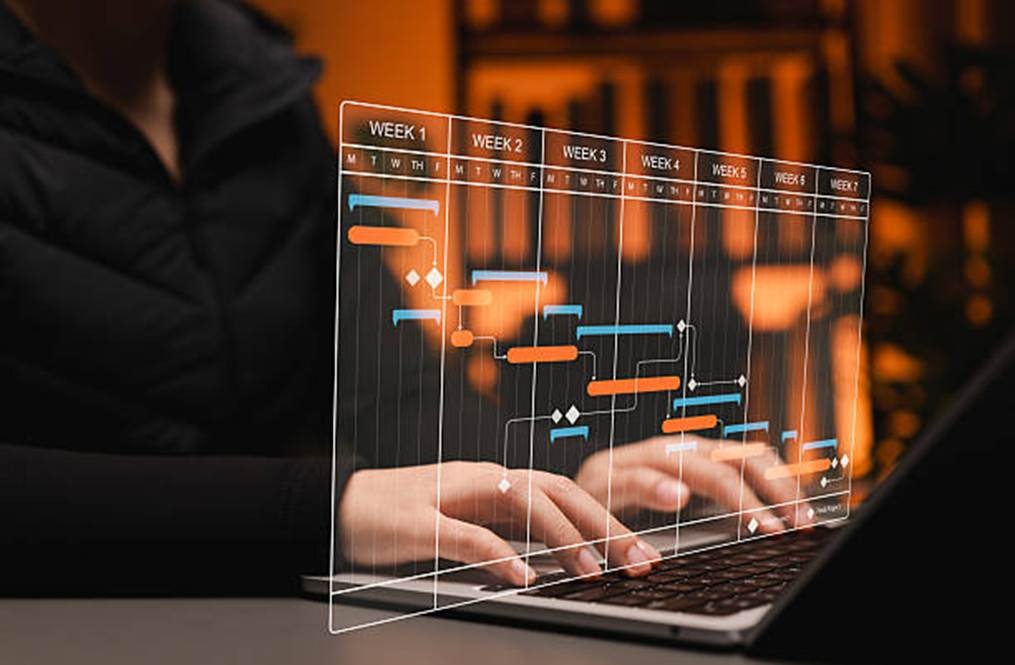 Digital project schedule interface over a laptop, representing integration with performance tools
