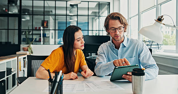 Two people looking at a tablet at a desk