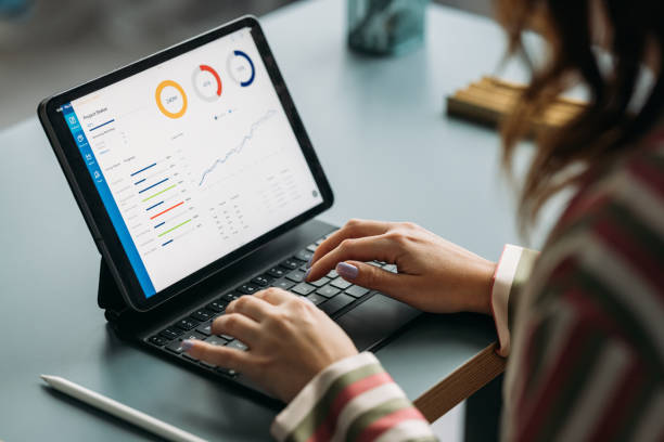 Person typing on a tablet with graphs