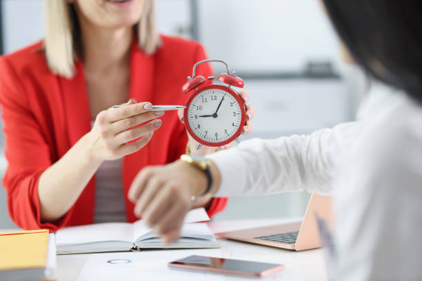 Woman holding a red alarm clock