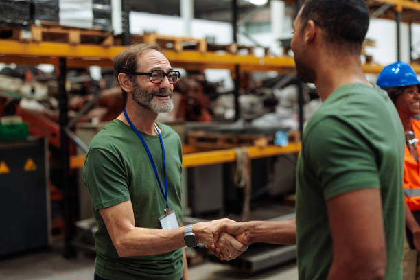 Two men shaking hands in a warehouse setting