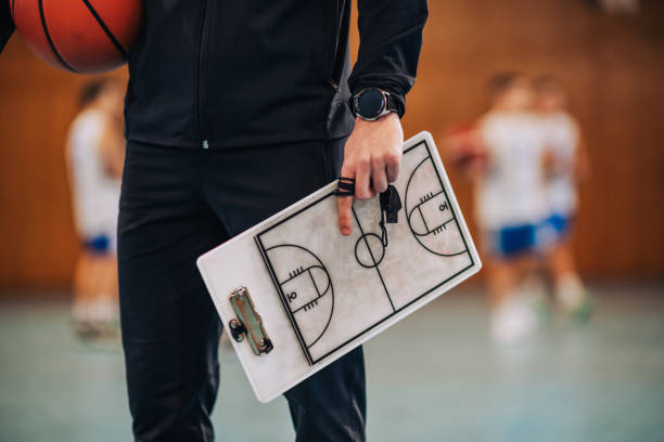 Manager holding a basketball and clipboard