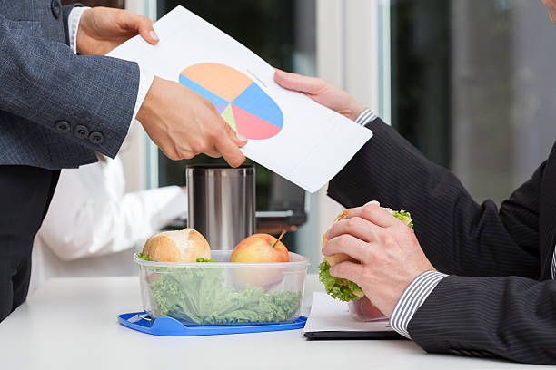 Hands exchanging paperwork over a meal