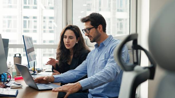 Employees looking at multiple computer screens