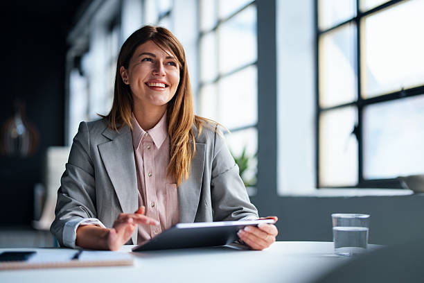 Smiling woman working at a desk with a tablet