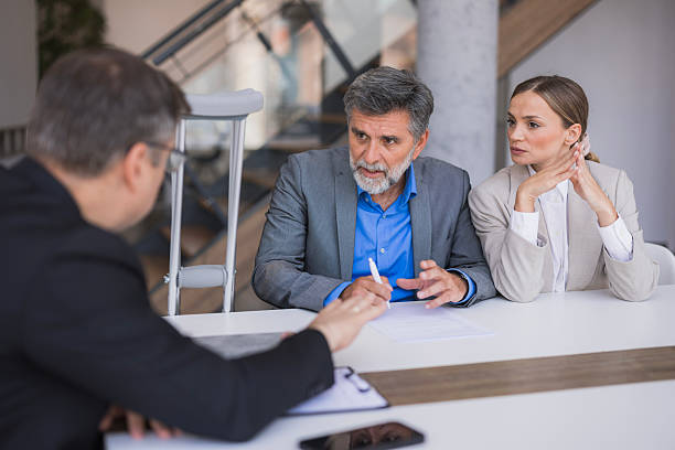 Three people in a meeting discussing documents