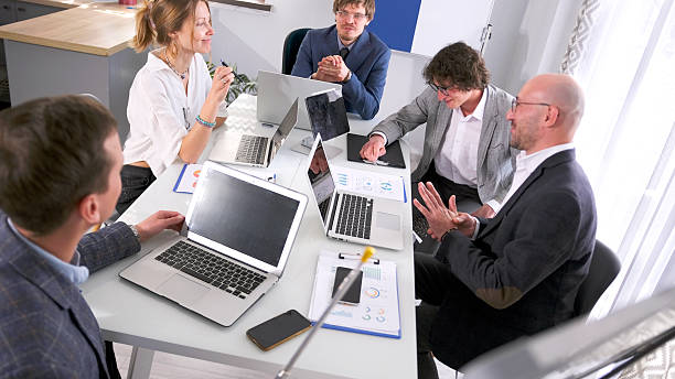 Employees looking at a laptop understanding the impact of missed deadlines