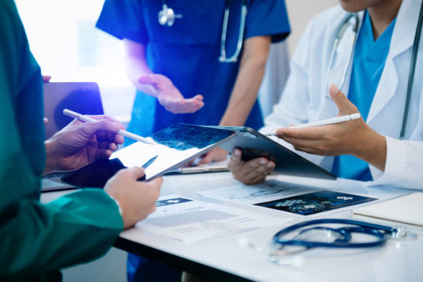 Medical professionals looking at a tablet and documents