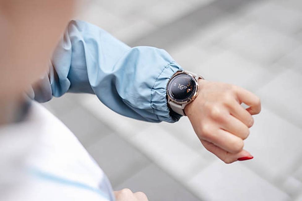 Person checking a smartwatch, representing time tracking and performance management