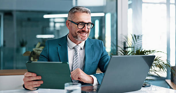 Manager smiling while looking at a laptop