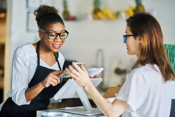 Two women interacting at a POS terminal