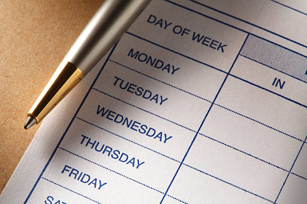 Pen pointing to a printed schedule with days of the week
