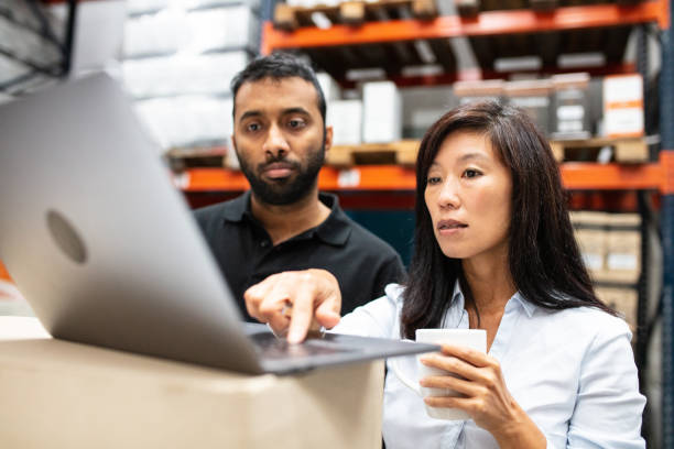 Two people looking at laptop in warehouse